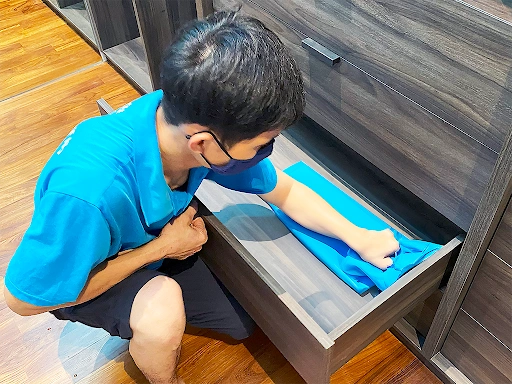 A Superb Cleaning staff cleaning the inside of a pullout wardrobe